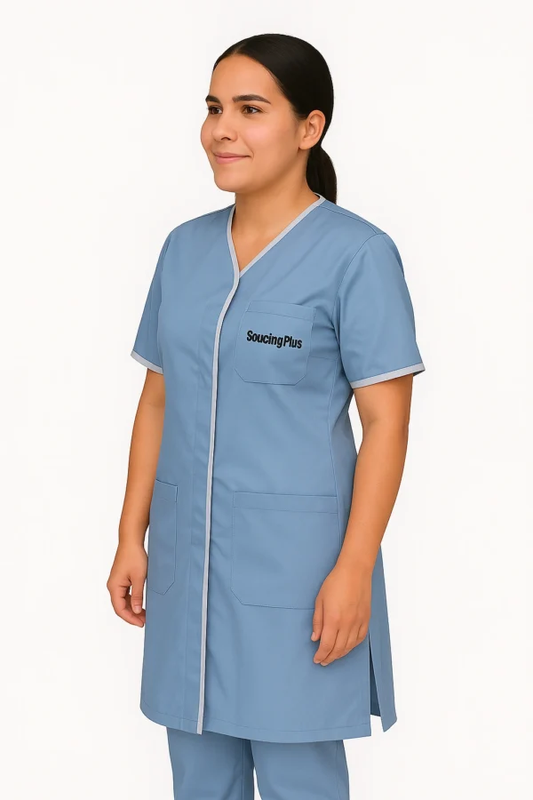 Femme en uniforme bleu ciel brodé "Sourcing Plus" – vue de face professionnelle